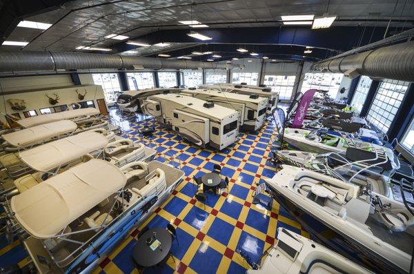 Large indoor showroom featuring fifth wheels, sport boats, travel trailers and more.