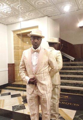 Tailored suit, bow tie, hat, and shoes.