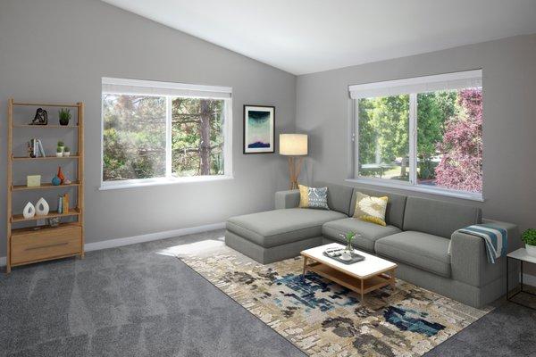 A living room with a sectional, rug, and windows to the outside