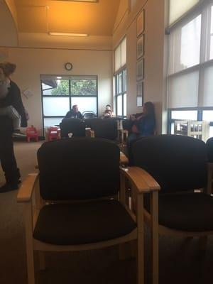 21 chairs in a clean, well lit waiting area with magazines and informative pamphlets, 2 small chairs for children to sit.