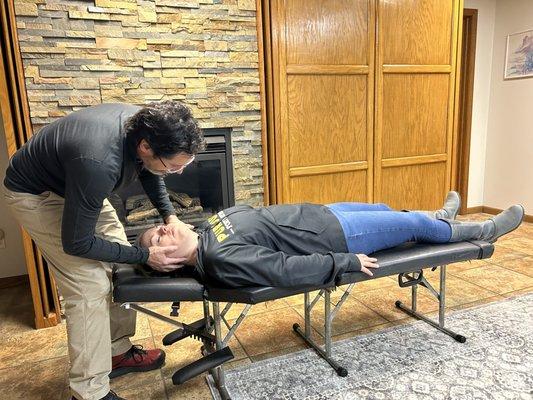 Patient receiving a neck adjustment in their home.