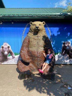 My daughter sitting in a big bear outside Living Treasures Animal Park