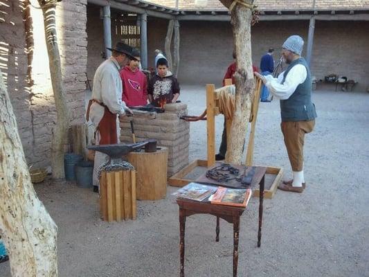 Blacksmith demonstration right next to the original cornerstone and pit house.