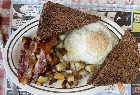 Fried eggs, bacon, home fries, and toast.