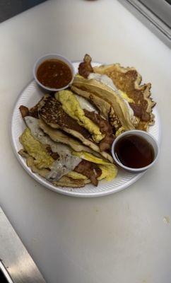 Breakfast tacos  pancakes con huevo y tocino y queso bañados en miel