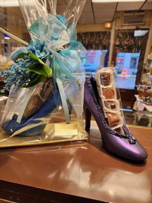 Lady's High Heel Shoe made entirely of Chocolate!  Filled with a 5 piece assortment of chocolates, finished with a silk floral cluster.