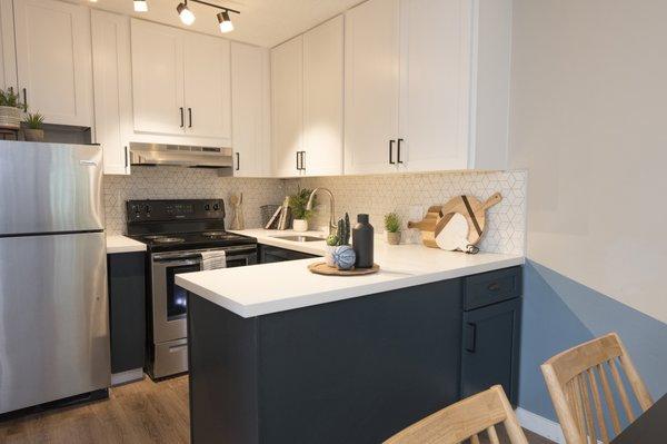 Modern kitchen with new stainless steel appliances and custom finishes.