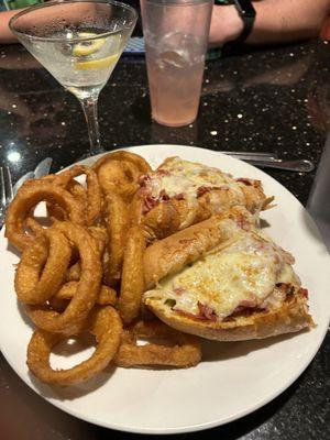 Onion rings and a pastrami sandwich with cheese & fried onions.