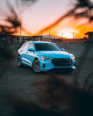 Audi E-Tron with chrome delete, custom badging, red brake calipers, and window tint.