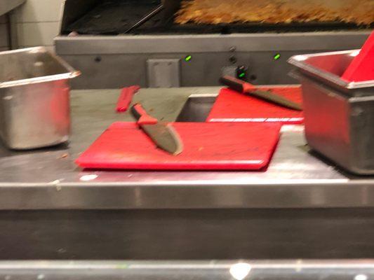 Prep table, both cutting boards full of some kind of meat seasoning.