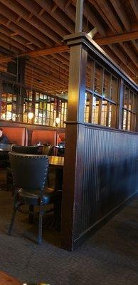 The interior is rich, dark wood, terra cotta red brick, private booths & long, open tables for groups of friends.