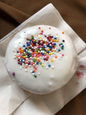 Raspberry filled doughnut with vanilla icing and sprinkles