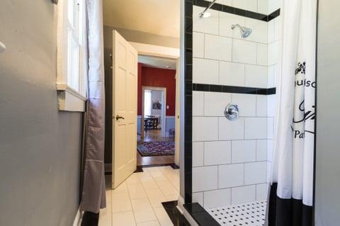 Beautiful tiled bathroom with large walk-in shower adjoins the 1940's Paris Room