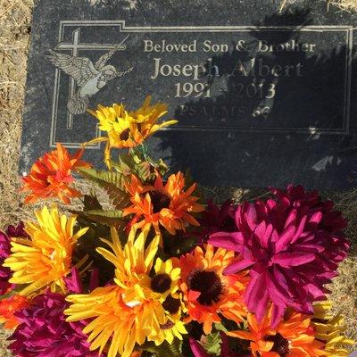 Notice the flowers look used and all the grass around the grave is dead - this cemetery is horrible.