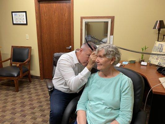 Dr. Larsen performing otoscopy on a patient's right ear