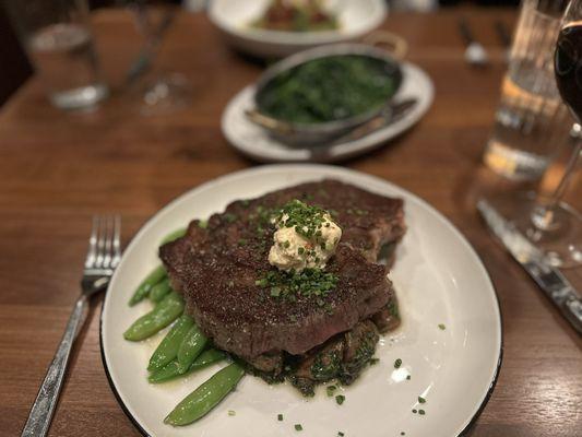 ribeye special with a side of spinach and kale in the background. Looks better than it is