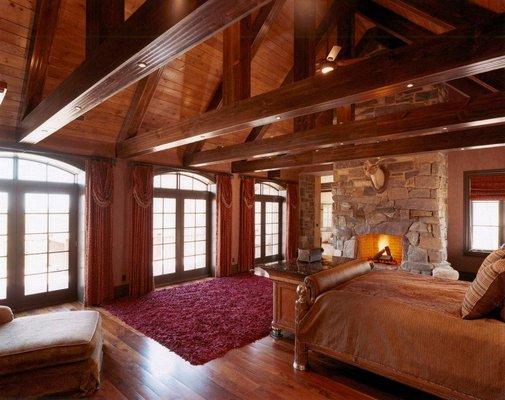 Master bedroom.  All new construction in the rocky mountain genre. Custom beam work, stone fireplace, french doors.