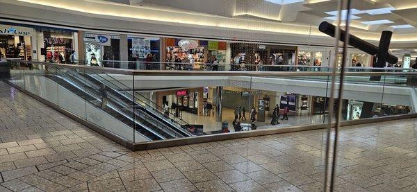 12/10/23 Bathrooms are outside the glass walls, down the escalator steps and to the far left past the Coldstone Ice Cream Store.