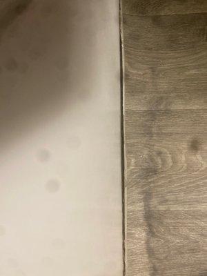 Cheap vinyl flooring is peeling next to bath tub