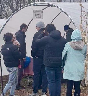 People in line to pick up their turkeys and thank Greg and Jenney in person. Also food bank donations and donuts!