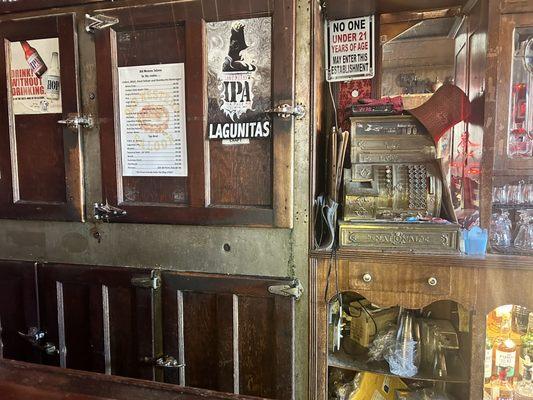 Behind bar with old cash register and ice box - pretty cool.