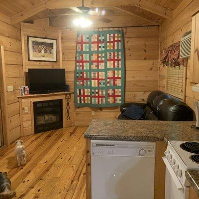 Living room with fireplace and TV and part of kitchen area.