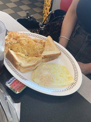 Yummy  hash browns, , sunny side up eggs  and toast