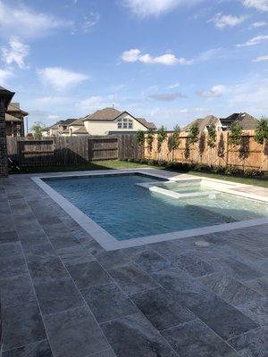 Finished new construction with travertine decking.