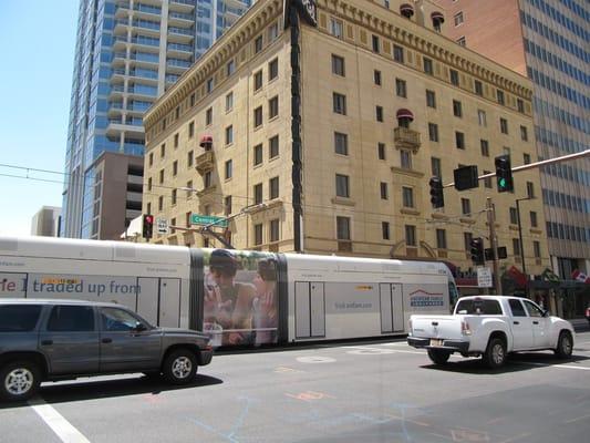 METRO light rail rolls past the Hotel San Carlos in downtown Phoenix.