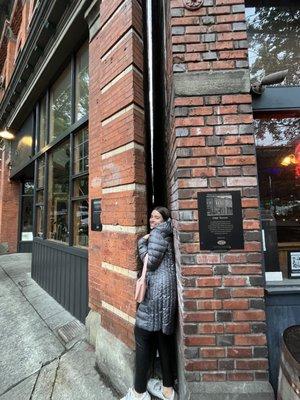 Outside with an very narrow gap between buildings.