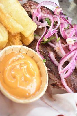 A beautiful marriage between Latin American cuisine and Texas' smoky delicacies: ribs, salsa de cebolla, cassava fries and sirracha sauce.