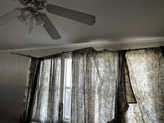 Broken curtain rods and dusty fan