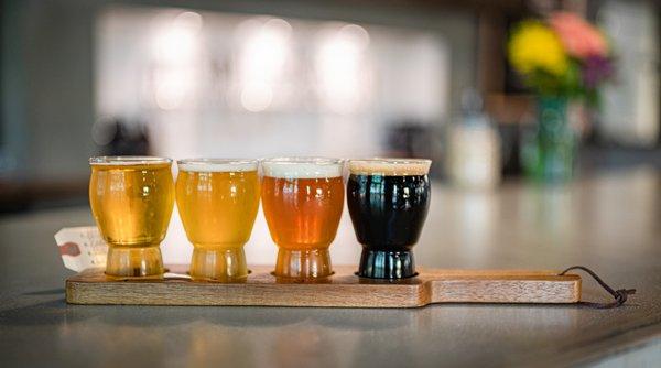 A flight of beers at the bar.