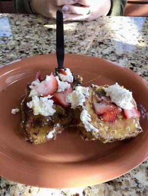 French toast with caramel syrup, whipped topping, and strawberries