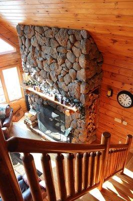 A custom, panelized log chalet with a large stone fireplace courtesy of Dorini LLC and Dorini Builders. www.dorinihomes.com