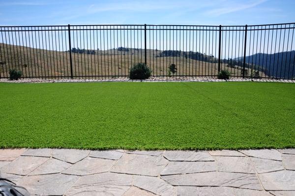 Artificial turf with ornamental wrought iron fence