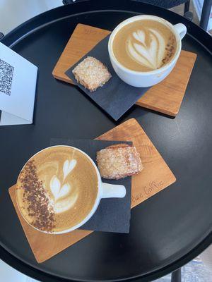 Two decaf cappuccinos with delicacies from the small patisserie.