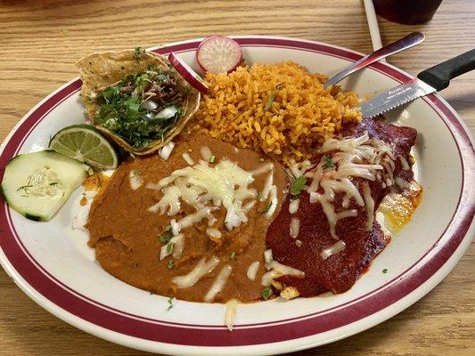 This is a chicken enchilada and carnitas street taco served with beans and rice.