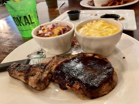 Juicy, well-cooked bone in pork chop with mac n cheese and chili