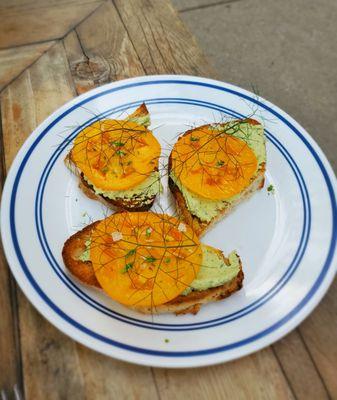 Tomato tartine with cashew ricotta pesto and basil blossom