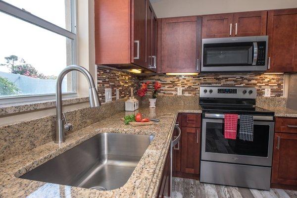 Spacious Single Bowl Undermount sink paired with a modern pull-out brush nickel faucet included with granite countertop.