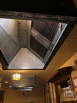 The grates on this exhaust fan are caked in grease and dust. There is no way that it's pulling the smoke outside!