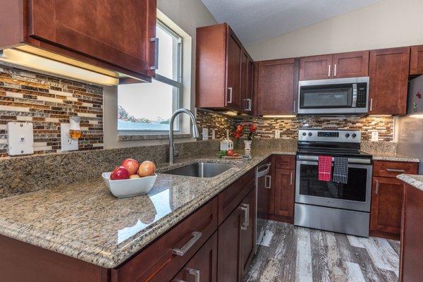 Kitchen cabinets, Granite Countertop, and Mosaic Tile Backsplash installed by Sanford Granite.