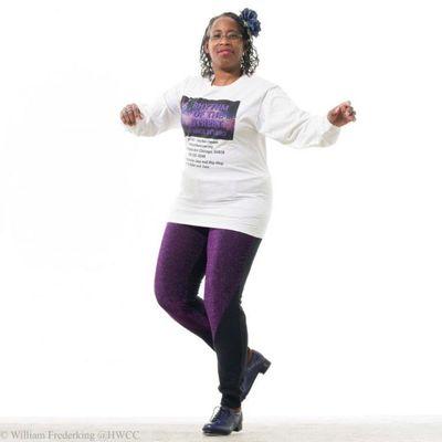 Lyn Cole tap dancing in purple pants and a Rhythm of the Street Dance Studio t-shirt.