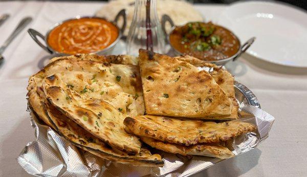 Garlic Naan (left) and Paneer Chili Naan (right); Butter Chicken and Goat Curry in the back