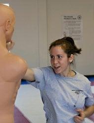 Self defense class - student practicing strikes to a heavy bag.