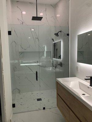 Inline frameless shower door enclosure with black matte hardware