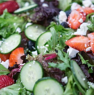 The best type of greens... topped with feta and strawberries