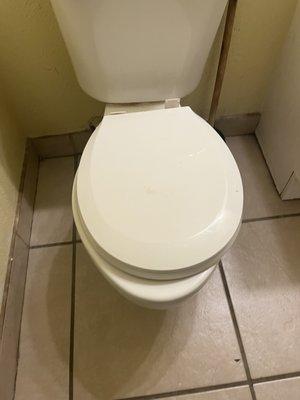 Round toilet seat on a oblong toilet. It isn't even bolted down