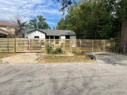 Custom, 6' tall treated pine fence with metal framed drive-gate and walkthrough gate.